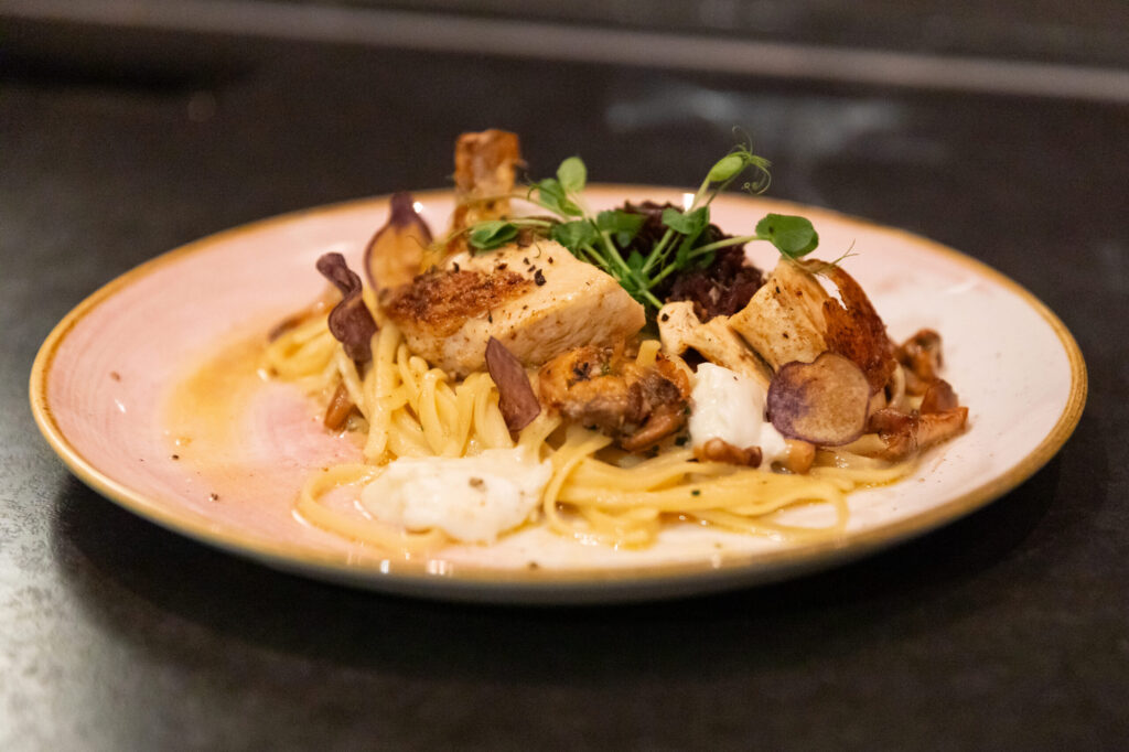 Angerichtetes Nudelgericht mit Fisch und Gemüse aus der Küche des Metzgerbräu.