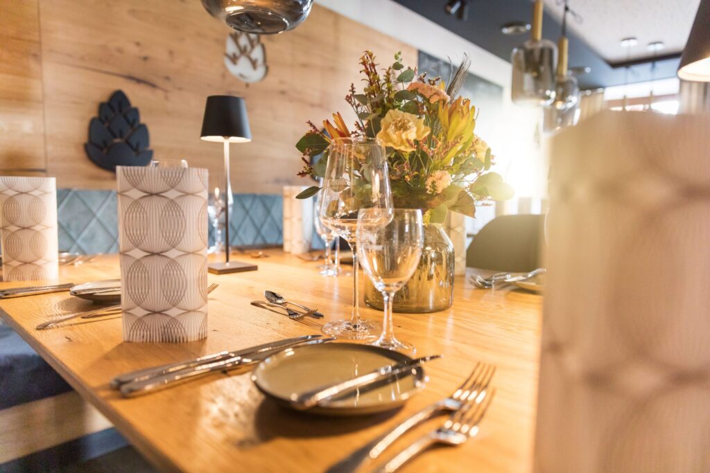 Gedeckter Holztisch mit Blumen und Weingläsern im Metzgerbräu Hohenwart.